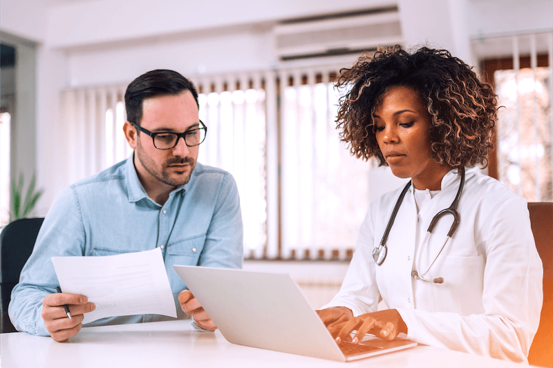 Man and woman looking at paperwork in medical setting