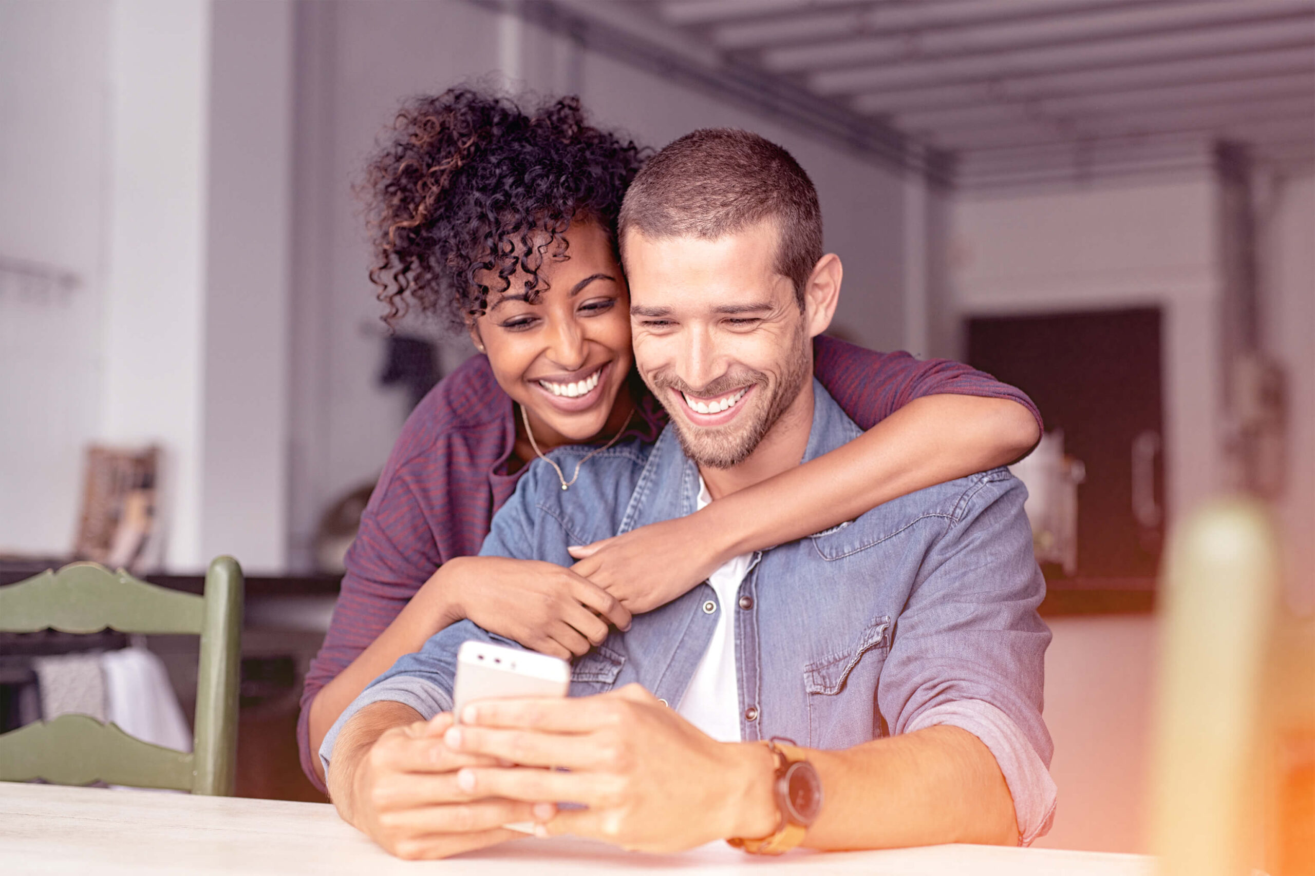 Couple looking happy at their phone